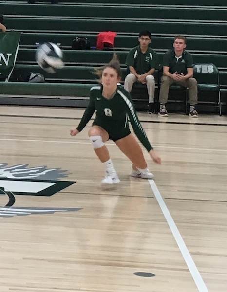 Carli Dugan preparing for a dig Tuesday night at Templeton High School. Coach Cameron Schaefer watches from the bench.